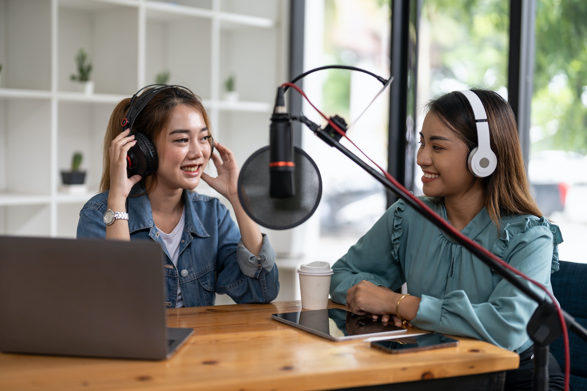 two-asian-radio-podcasters-recording-interview-each-other-for-radio-podcast-.jpg